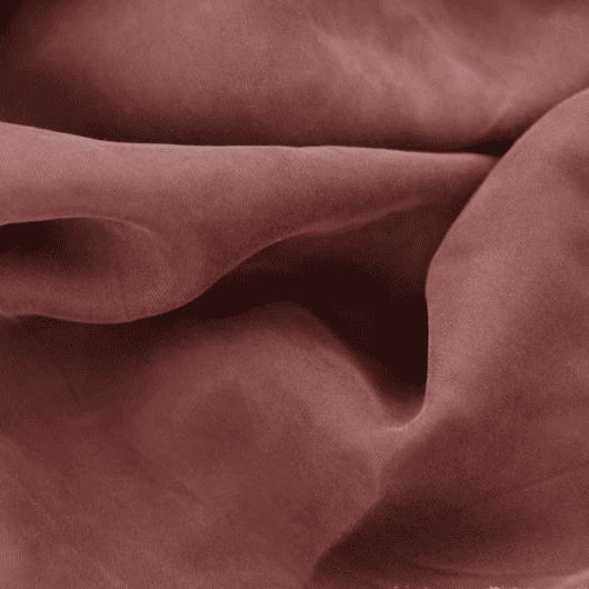 Close-up of a soft, flowing viscose blend fabric in a muted rose-brown shade, highlighting its smooth texture and fluid drape