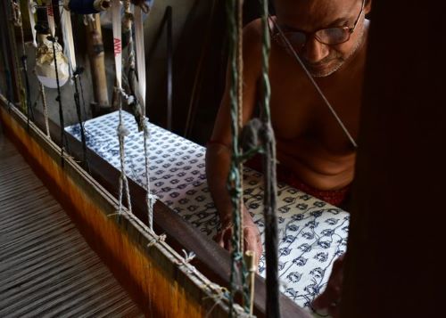 Artisan Weaving Fabric on Loom